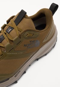 Brown mesh hiking shoe with a textured finish, featuring a reinforced toe, rubber sole, and branding on the side. Lightweight design.