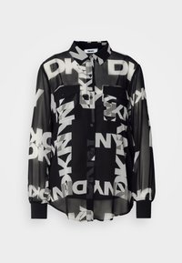 Gjennomsiktig svart skjorte med knapper som har dristige hvite DKNY-logoer, to frontlommer og elastiske mansjetter på lange ermer. Lett stoff.