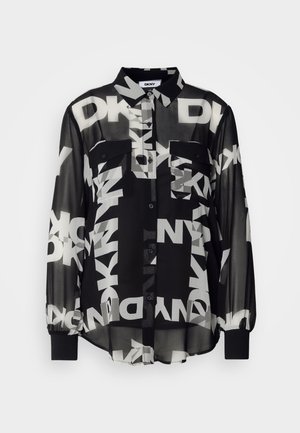 Chemise noire transparente à boutons avec de grands logos blancs DKNY, deux poches avant et des poignets élastiques sur les longues manches. Tissu léger.