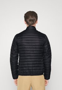Schwarze Daunenjacke mit einem gesteppten Design, Reißverschlusskragen und langen Ärmeln. Glatte Textur mit horizontalen Steppnähten.