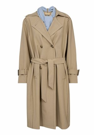 Bēšā krāsā trenčmētelis ar dubultpogu aizdari, atbilstošu jostas siksnu, šuvju detaļām un gaiši zilas krāsas šalli pie apkakles.