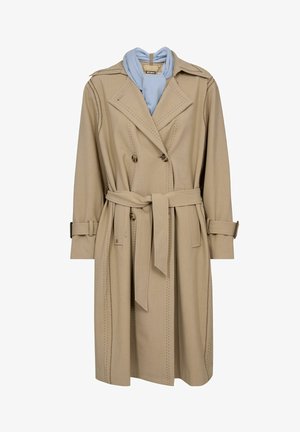 Bēšā krāsā trenčmētelis ar dubultpogu aizdari, atbilstošu jostas siksnu, šuvju detaļām un gaiši zilas krāsas šalli pie apkakles.