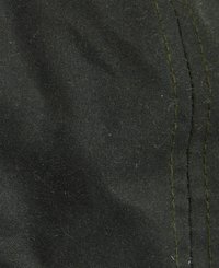 Tecido texturizado verde escuro com costura visível em verde mais claro. O material parece durável e ligeiramente peludo, com fibras menores.