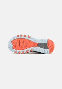 Suela de un zapato con una base azul y acentos en naranja y gris. La superficie texturizada incluye patrones hexagonales y surcos para tracción.