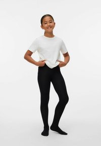 Vit kortärmad t-shirt i kombination med svarta, ribbade leggings. Outfiten är enkel, slim-fit och designad för komfort och rörelsefrihet.