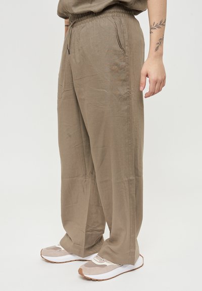 Pantaloni khaki realizzati in tessuto leggero, con una vestibilità ampia, cintura elastica, tasche laterali e un dettaglio di branding discreto.