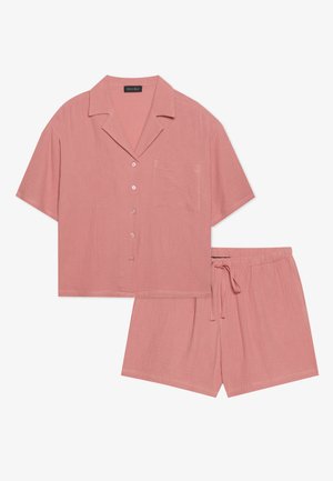Kurze Ärmel, knöpfbares Hemd mit einer Brusttasche und passenden Shorts. Beides aus einem weichen, pinkfarbenen Stoff mit einer strukturierten Oberfläche.