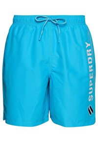 Bañadores de hombre en azul brillante, fabricados con material ligero. Presentan una cinturilla elástica con cordón y el logo 'SUPERDRY' impreso en el lateral.