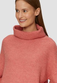 Strickpullover in sanftem Rosa mit einem breiten, gerippten Rollkragen. Hat ein strukturiertes Muster und eine lockere Passform, mit überschnittenen Schultern.