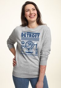 Felpa grigia con un design retro, con testo blu "RETRO DETROIT" e grafica di un personaggio di basket. Polsini e orlo a coste.