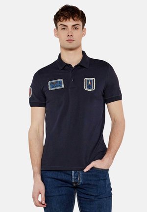 Polo shirt blu navy in cotone, con maniche corte, tre bottoni e diversi ricami in blu, rosso e bianco.