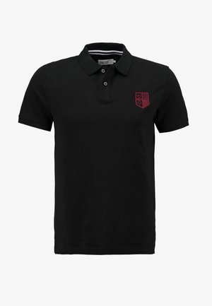 Zwarte poloshirt van katoen, met een drieknops sluiting en een rood geborduurd embleem op de linkerborst. Korte mouwen.
