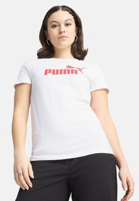 T-shirt bianco in cotone con un audace logo "PUMA" rosso e una piccola silhouette iconica di puma. Maniche corte e vestibilità standard.