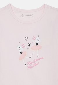 Δύο λευκά κουνελάκια με ροζ τουτού χορεύουν μπαλέτο με αστέρια πάνω και το κείμενο «Μεγάλα όνειρα, μικρά δαχτυλάκια» σε ανοιχτό ροζ μπλουζάκι.