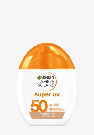 Bouteille de crème solaire avec un corps ovale blanc et un bouchon orange à clapet. Porte la marque "Garnier Ambre Solaire" et une étiquette SPF 50.
