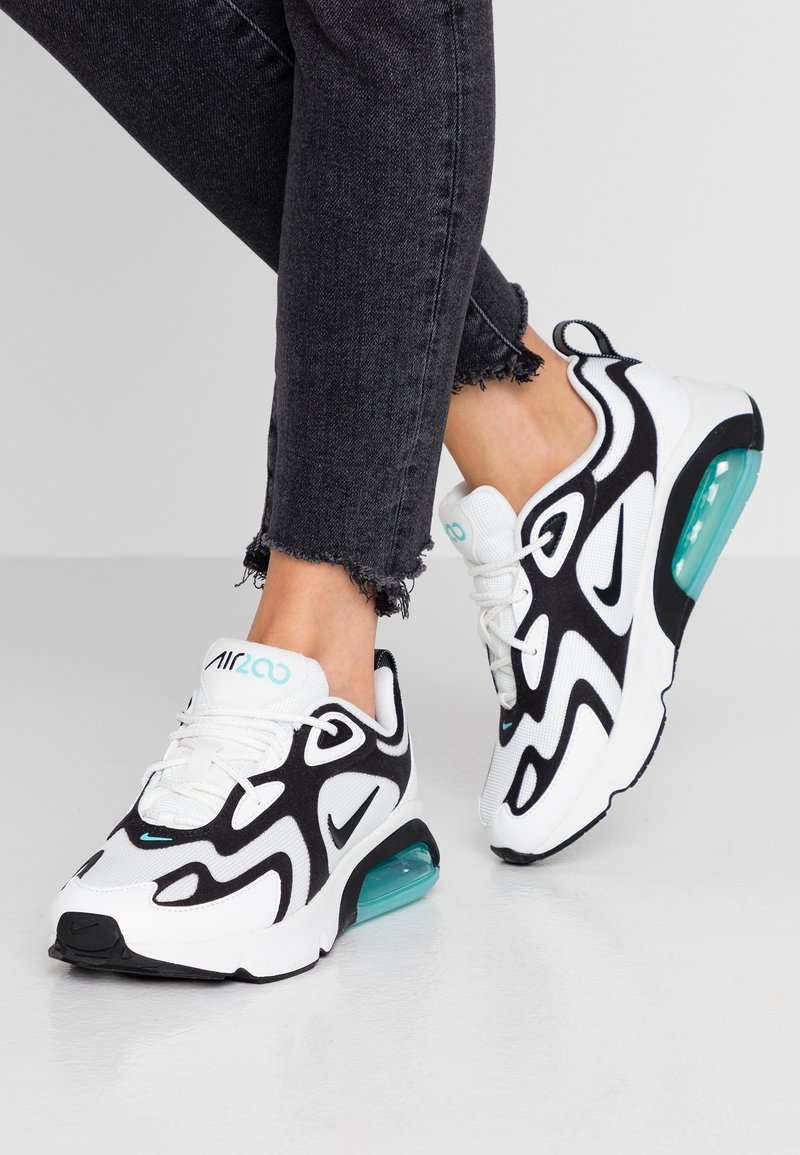 Vita och svarta idrottssneakers med en strukturerad ovansida, distinkt vågig design och en aquafärgad luftenhet i sulan; snörda med en logotyp.