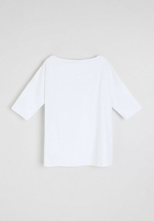 Biała, luźna bluzka z szerokim dekoltem, rękawami o długości trzech czwartej i prostym dołem. Wykonana z miękkiego, gładkiego materiału bez wzorów.