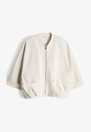 Cremefarbenes, kurz geschnittenes Jackett mit kurzen, weiten Ärmeln, einem Reißverschluss vorne und zwei großen Pattentaschen vor weißem Hintergrund.