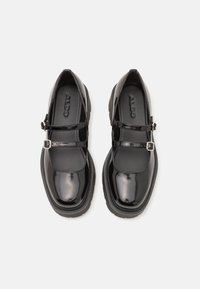 Black patent leather Mary Jane shoes with two strap design, silver buckle accents, rounded toe, and textured rubber soles.