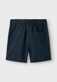 Shorts en coton bleu marine avec une taille élastique, deux poches arrière et des ourlets reversés. Texture lisse avec un design simple.