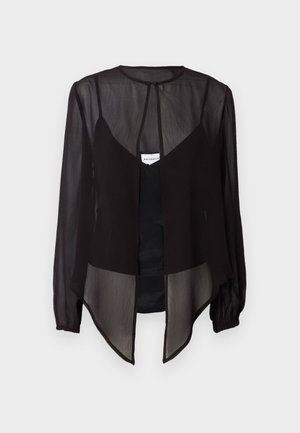 Blusa nera trasparente con maniche lunghe, collo alto e orlo asimmetrico. Presenta una chiusura frontale con bottoni e elementi di design a strati.