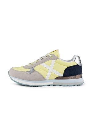 Multicolor sneaker featuring yellow and grey upper with suede and mesh textures, white accents, silver heel, and a textured rubber sole.