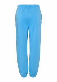 Pantalones sudorosos azules hechos de una tela suave, con una cinturilla elástica y puños elásticos en los tobillos, y con bolsillos laterales.