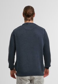 Dunkelblauer gestrickter Pullover mit geripptem Halsausschnitt, Bündchen und Saum. Verfügt über eine lockere Passform und strukturierte Stoff. Rückansicht, keine sichtbaren Logos.
