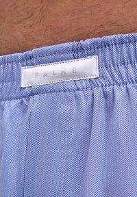 Boxer bleu et blanc à motif chevrons pour hommes, avec une ceinture élastique et une étiquette en tissu blanche portant l'inscription "FALKE".