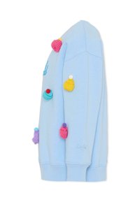 Jasnoniebieska bluza z dzianinowymi zdobieniami w kształcie babeczek w kolorze różowym, żółtym i fioletowym. Posiada ściągacze przy mankietach i haftowane logo.