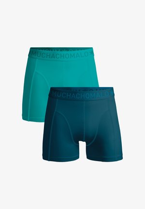 Herenboxerslips in turquoise en donker turquoise. Zachte, rekbare stof met elastische taillebanden met de tekst "MUCHACHOMOLO", een aansluitend ontwerp en zonder patronen.