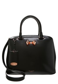 Sac à main en cuir noir avec deux poignées supérieures, une bandoulière amovible et un nœud en or rose en accent sur le devant. Comprend une étiquette de bagage.