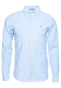 Camisa de botón de manga larga azul claro con cuello abotonado y pequeño logo de Tommy Hilfiger en el lado izquierdo del pecho.
