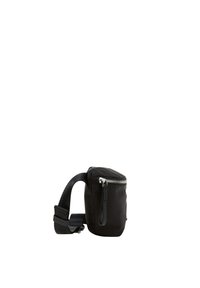 Sac noir avec une fermeture à glissière, fabriqué en matériau lisse. Il dispose d'une seule bandoulière réglable et d'une petite poignée de transport sur le dessus.