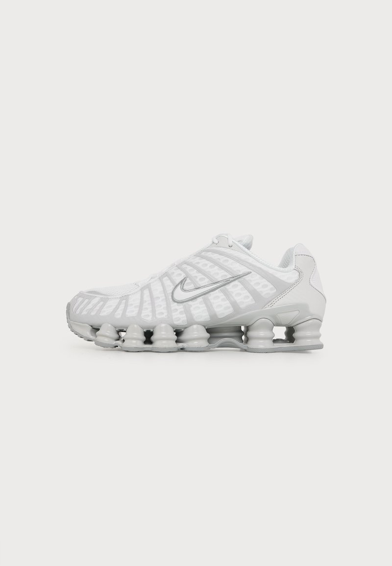Λευκό αθλητικό παπούτσι Nike με ορατή αεριζόμενη σόλα και ασημένιο λογότυπο Swoosh στο πλάι, απεικονιζόμενο από την εξωτερική πλευρά.
