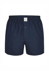 Marineblauwe katoenen boxershorts met een elastische tailleband, een knoopsluiting aan de voorkant en een klein merklabel bovenaan in het midden.