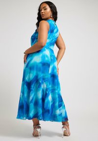 Maksimekko sinisävyissä vesiväri-kuvioissa, olkaimeton malli ja avainreiän muotoinen selkäosa. Sujuvasti laskeutuva kangas, joka tekee siitä elegantin.