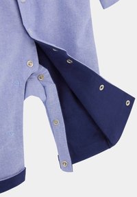 Camicia a maniche corte in tessuto a trama azzurro chiaro con accenti blu navy, caratterizzata da bottoni a pressione lungo l'orlo e il pattino.