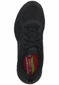 Scarpa sportiva nera con tomaia in tessuto a rete, chiusura con lacci e soletta imbottita etichettata "Air-Cooled Arch Fit." Dettagli suola in gomma resistente.