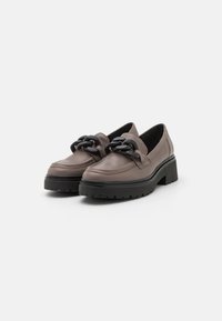 Brown leather platform shoes with a chunky black chain accent on the front. Thick rubber sole with textured tread pattern.