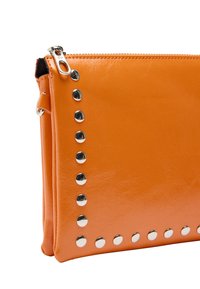 Pomarańczowa torebka kopertowa z syntetycznej skóry z metalowymi ćwiekami wzdłuż jednej strony, z zamknięciem na zamek u góry. Gładka tekstura.