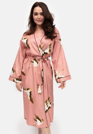 Robe en satin rose à manches longues, ornée de motifs de grues, avec un passepoil noir contrastant et une ceinture à nouer pour la fermeture.