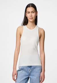 Top de tirantes de canalé gris claro con escote redondo y diseño sin mangas. La tela parece suave y ceñida, complementando unos vaqueros de denim holgados.