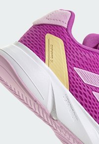 Scarpa sportiva a rete rosa con suola bianca e rosa chiaro, dettaglio dorato con "Duramo SL" e particolari testurizzati sulla parte superiore.