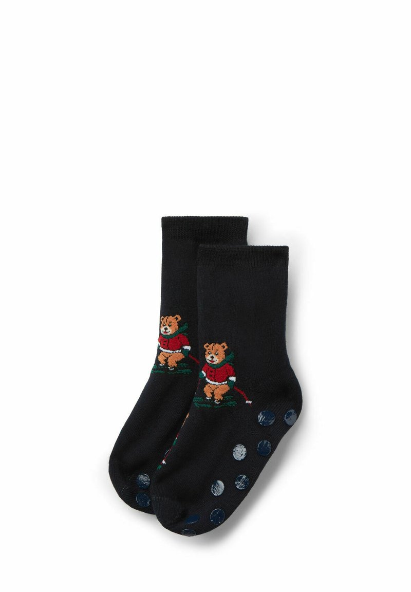 Calcetines negros con un oso bordado vestido de rojo, con detalles en verde. Las suelas tienen lunares azules para mayor agarre y textura.