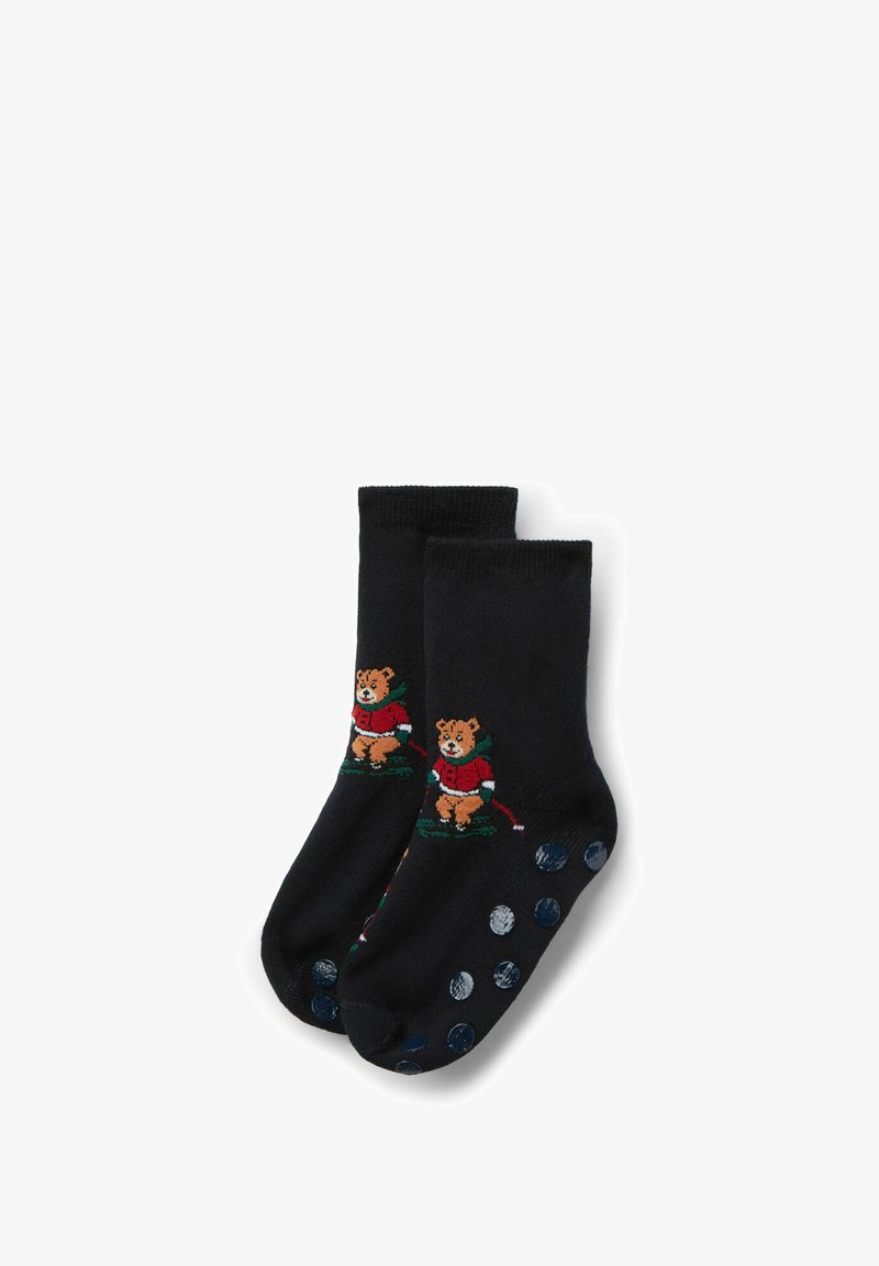 Calcetines negros con un oso bordado vestido de rojo, con detalles en verde. Las suelas tienen lunares azules para mayor agarre y textura.