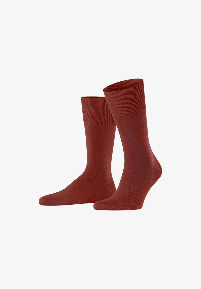 Rote Socken mit einer glatten Textur, ausgestattet mit einem gerippten Bund und einer enganliegenden Form. Das Design ist schlicht und weist keine zusätzlichen Muster oder Akzente auf.