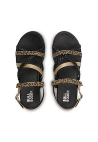 Czarne sandały z paskami w zwierzęcy wzór, metalicznymi akcentami, plecionkami oraz regulowanym zapięciem na kostkę. Podeszwa jest płaska i teksturowana.