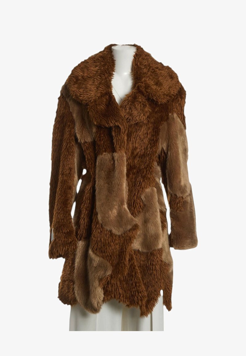 Manteau en fausse fourrure marron avec un design patchwork, col large et manches longues, présenté sur un buste de mannequin blanc.