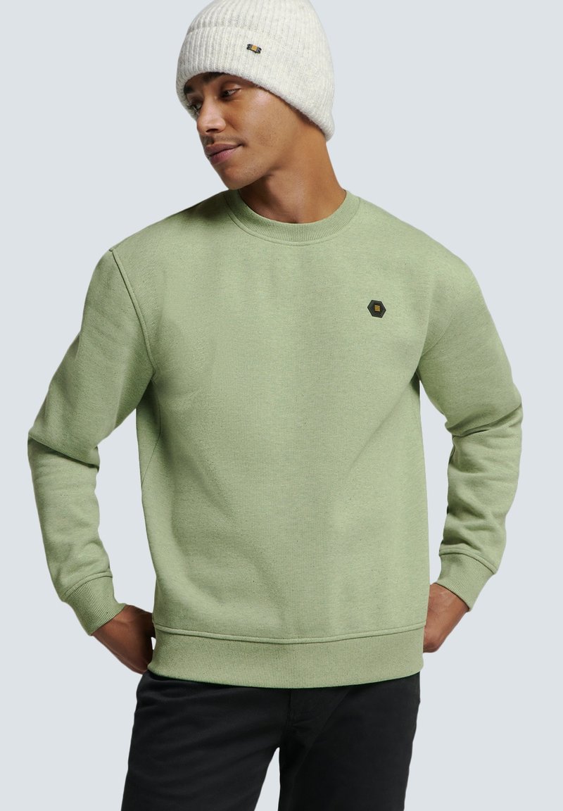 Groene sweatshirt met een ronde hals en ribgebreide manchetten, voorzien van een klein hexagonaal logo op de borst. Warme gebreide beanie in lichtgrijs.
